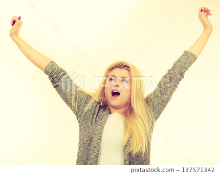 Bored, sleepy woman stretching and yawning Bored, sleepy woman stretching and yawning 137571342