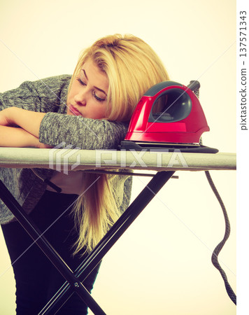 Sleepy tired woman having clothes to iron 137571343