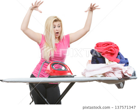 Woman holding iron about to do ironing 137571347