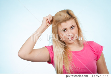 Woman brushing her long blonde hair with comb Woman brushing her long blonde hair with comb 137571353