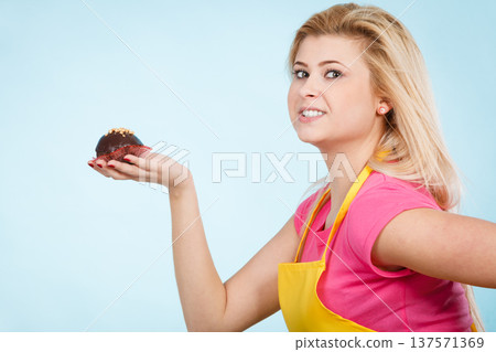 Woman holding chocolate cupcake about to bite Woman holding chocolate cupcake about to bite 137571369