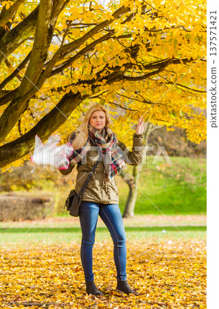 Woman walking in park with umbrella Woman walking in park with umbrella 137571421