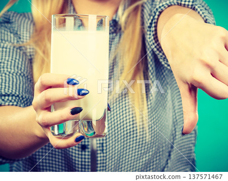 Woman holding milk glass showing thumb down 137571467