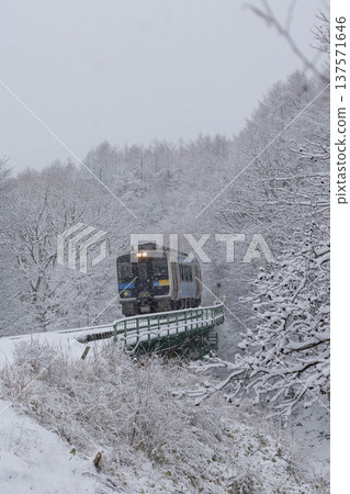 Koumi Line Kiha 200 series train crossing the railway bridge at the prefectural border in the snow Koumi Line Kiha 200 series train crossing the railway bridge at the prefectural border in the snow 137571646
