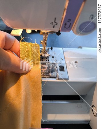 Sewing on sewing machine, close-up of presser foot during sewing lesson 137572087