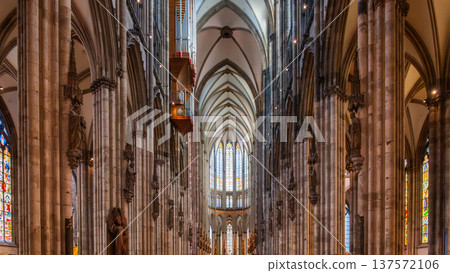 Interior view of Cologne Cathedral in Germany. Tall stone columns, intricate arches, and colorful stained glass windows create a majestic atmosphere. Interior view of Cologne Cathedral in Germany. Tall stone columns, intricate arches, and colorful stained glass windows create a majestic atmosphere. 137572106