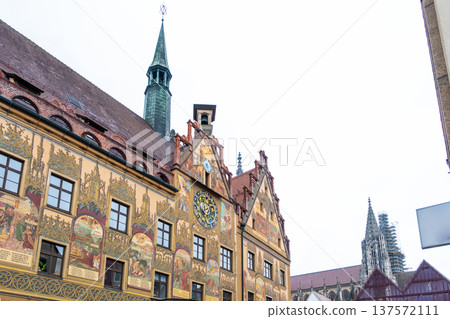 Historic Ulm Rathaus building in Germany features intricate frescoes and a tall spire. The architecture showcases traditional German design elements. 137572111