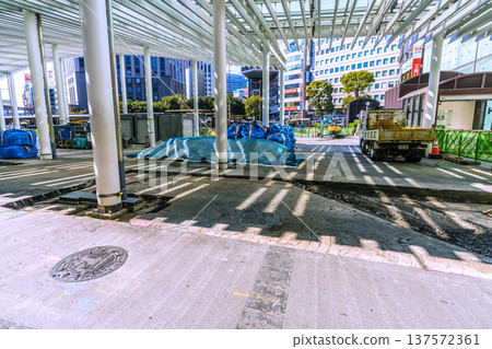 Yokohama cityscape, Japan, March 11. Work is underway to repair the damaged sidewalk at the west exit of Yokohama Station. Materials, heavy machinery, and waste are lined up. 137572361