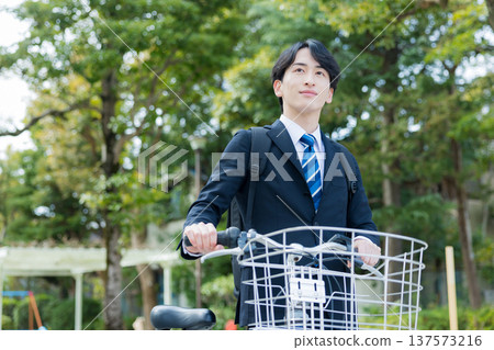 Businessman walking while pushing a bicycle Businessman walking while pushing a bicycle 137573216