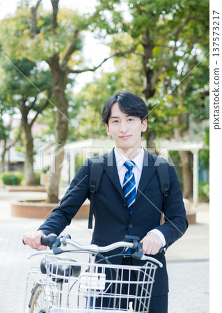 Businessman walking while pushing a bicycle 137573217