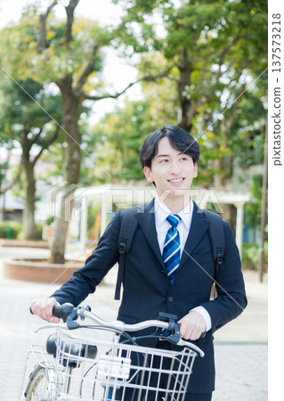 Businessman walking while pushing a bicycle 137573218