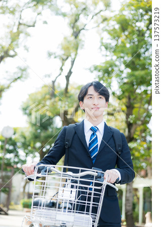 Businessman walking while pushing a bicycle Businessman walking while pushing a bicycle 137573219
