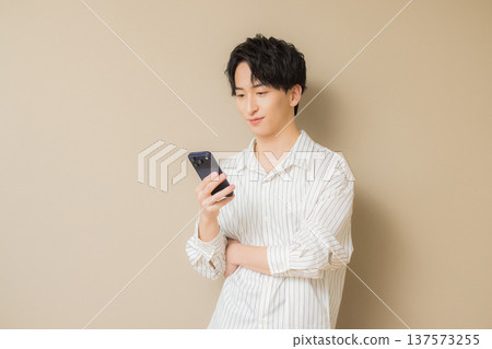 A young man looking at his smartphone A young man looking at his smartphone 137573255