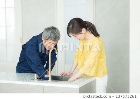 A man in work clothes explaining about plumbing 137573261