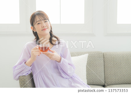 Woman drinking tea in the living room 137573353