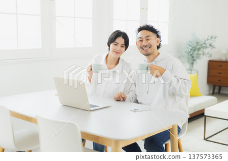Couple looking at a computer at home Couple looking at a computer at home 137573365