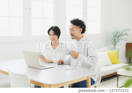A woman watching a computer at home A woman watching a computer at home 137573372