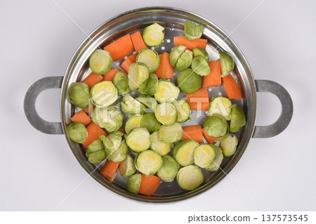 Brussels Sprouts and Carrots in Steamer Pot 137573545