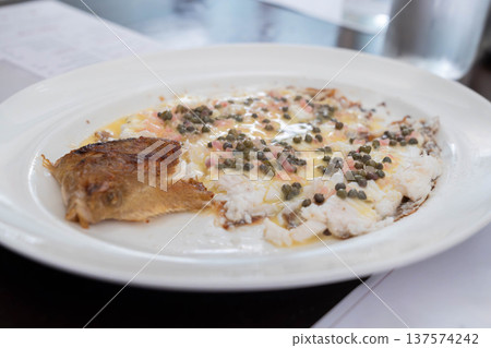 Pan cooked white fish served with capers and butter sauce in a classic European restaurant style dish. 137574242