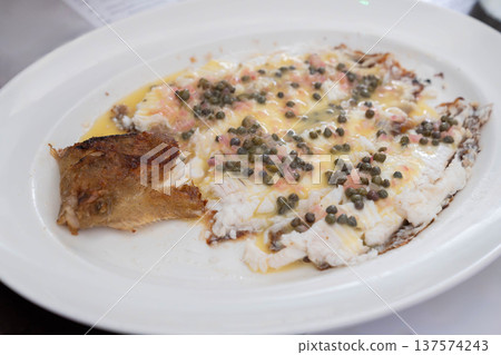 Pan cooked white fish served with capers and butter sauce in a classic European restaurant style dish. Pan cooked white fish served with capers and butter sauce in a classic European restaurant style dish. 137574243