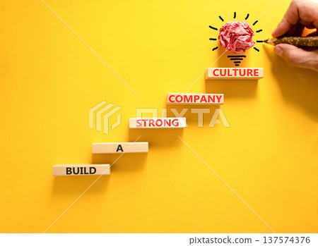 Strong company culture symbol. Concept words Build a strong company culture on beautiful wooden blocks. Beautiful yellow paper background. Business strong company culture concept. Copy space. 137574376
