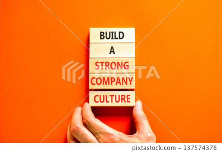 Strong company culture symbol. Concept words Build a strong company culture on beautiful wooden blocks. Beautiful orange paper background. Business strong company culture concept. Copy space. 137574378