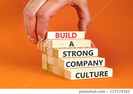 Strong company culture symbol. Concept words Build a strong company culture on beautiful wooden blocks. Beautiful orange paper background. Business strong company culture concept. Copy space. 137574385