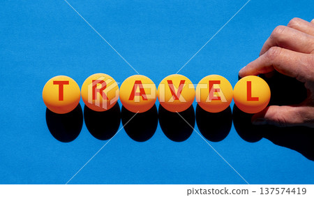 Travel traveling touristic word symbol. Concept word Travel on beautiful orange table tennis ping pong balls. Beautiful blue background. Business travel traveling touristic word concept. Copy space. Travel traveling touristic word symbol. Concept word Travel on beautiful orange table tennis ping pong balls. Beautiful blue background. Business travel traveling touristic word concept. Copy space. 137574419