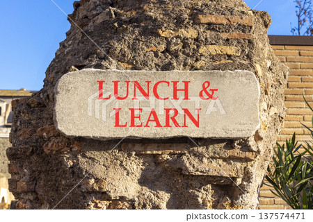 Lunch and learn symbol. Concept words Lunch and learn on beautiful big white sign plate. Beautiful old brown brick wall background. Business, educational and lunch and learn concept. Copy space. 137574471