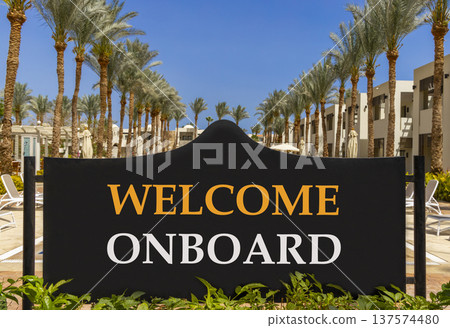 Welcome onboard symbol. Concept words Welcome onboard on beautiful big black road sign. Beautiful blue sky palm trees background. Business, motivational welcome onboard concept. Copy space. 137574480