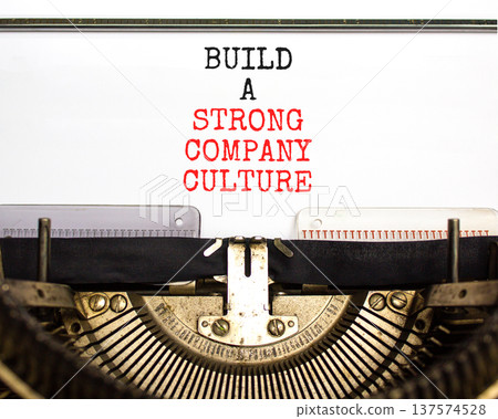 Strong company culture symbol. Concept words Build a strong company culture typed on old retro typewriter. Beautiful white background. Business strong company culture concept. Copy space. 137574528