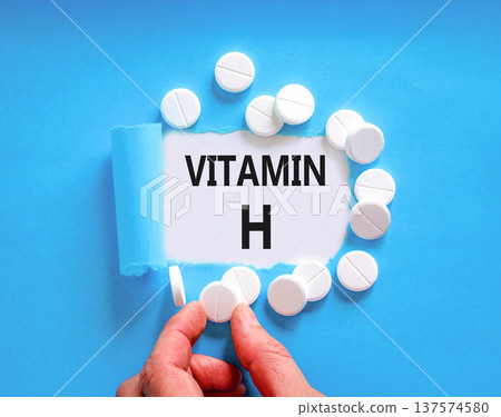 Vitamin H symbol. Concept words Vitamin H on beautiful white paper. White pills tablets. Doctor's hand. Beautiful blue background. Medical healthy lifestyle Vitamin H concept. Vitamin H symbol. Concept words Vitamin H on beautiful white paper. White pills tablets. Doctor's hand. Beautiful blue background. Medical healthy lifestyle Vitamin H concept. 137574580