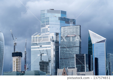 Modern glass skyscrapers in the London financial district rise across the River Thames representing contemporary urban architecture and a dynamic business city skyline. Modern glass skyscrapers in the London financial district rise across the River Thames representing contemporary urban architecture and a dynamic business city skyline. 137574651