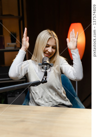 Radio host speaking with energy during a live podcast recording 137574809