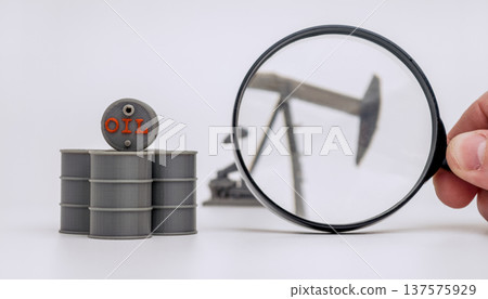 Magnifying Glass over Oil Barrels and Pumpjack on White 137575929