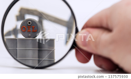 Close Up Magnifying Glass Inspecting Oil Barrels and Pumpjack Close Up Magnifying Glass Inspecting Oil Barrels and Pumpjack 137575930