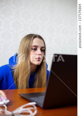 Young woman reacts with surprise to political news on laptop. Mouth slightly open, hand on mouse, she processes shocking statement from president or leader. Citizen engaged in current events Young woman reacts with surprise to political news on laptop. Mouth slightly open, hand on mouse, she processes shocking statement from president or leader. Citizen engaged in current events 137576804