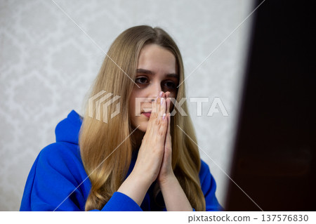 Hopeful young woman seeks crowdfunding support online, hands clasped in plea. She launches campaign for startup, medical aid, or creative project. Fundraising concept Hopeful young woman seeks crowdfunding support online, hands clasped in plea. She launches campaign for startup, medical aid, or creative project. Fundraising concept 137576830