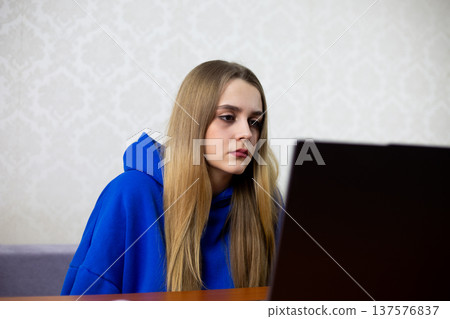 Bored blonde girl reluctantly attends online class on laptop. She lacks motivation to study, distracted and uninterested in remote learning. Student struggles with home education Bored blonde girl reluctantly attends online class on laptop. She lacks motivation to study, distracted and uninterested in remote learning. Student struggles with home education 137576837