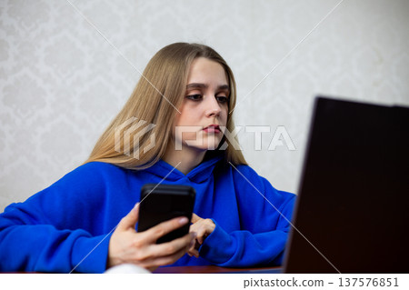 Confused blonde girl stares at laptop screen after losing bet online. Her gambling addiction leaves her frustrated and unsure what went wrong. Risky behavior concept 137576851