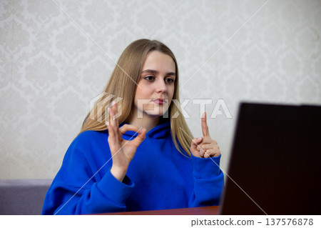 Confident blonde football fan displays one finger and zero showing 1-0 score. She calmly celebrates her team leading match with minimal advantage. Satisfied supporter at home Confident blonde football fan displays one finger and zero showing 1-0 score. She calmly celebrates her team leading match with minimal advantage. Satisfied supporter at home 137576878