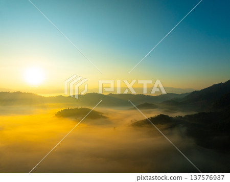 Aerial view of flowing fog waves on mountain tropical rainforest,Bird eye view image over the clouds Amazing nature background with clouds and mountain peaks in Thailand Aerial view of flowing fog waves on mountain tropical rainforest,Bird eye view image over the clouds Amazing nature background with clouds and mountain peaks in Thailand 137576987