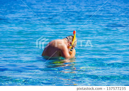 Man with snorkeling tube in sea Man with snorkeling tube in sea 137577235