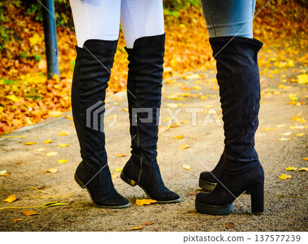 Two women wearing black knee high boots 137577239