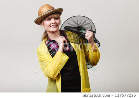 Happy woman holding empty fishing keepnet Happy woman holding empty fishing keepnet 137577250