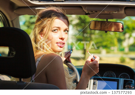 Girl apply make up while driving car. Girl apply make up while driving car. 137577293