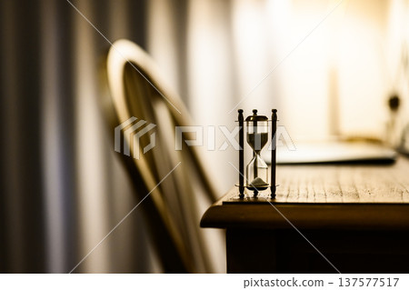 Hourglass and chair on the desk Hourglass and chair on the desk 137577517