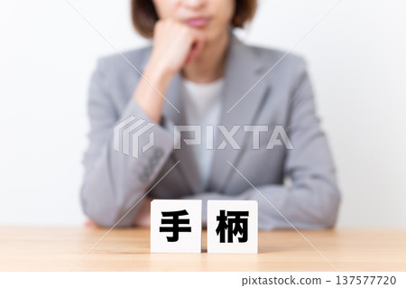 A middle-aged woman in a suit worried about her achievement block 137577720