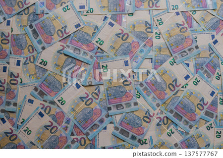 Dense texture of 20 Euro banknotes in a dynamic arrangement. Detailed macro shot of blue European currency featuring holograms and watermarks. Financial abundance concept Dense texture of 20 Euro banknotes in a dynamic arrangement. Detailed macro shot of blue European currency featuring holograms and watermarks. Financial abundance concept 137577767