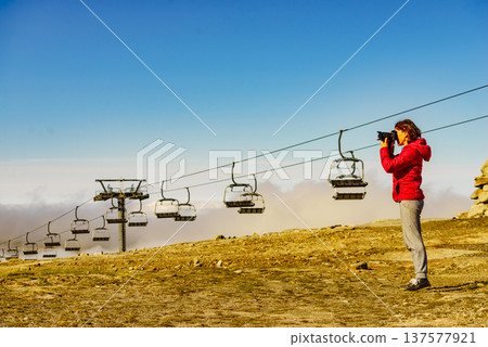 Woman with camera in mountains take travel photo Woman with camera in mountains take travel photo 137577921
